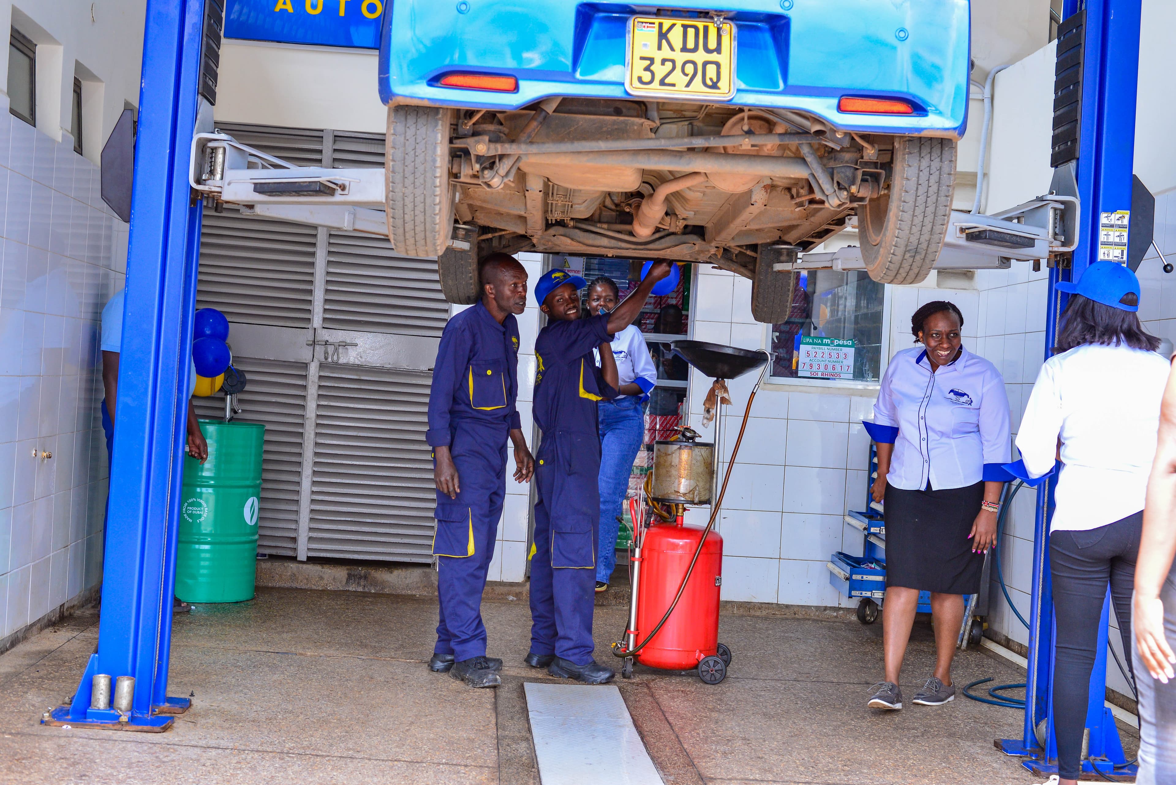 Workshop team standing in front of a vehicle